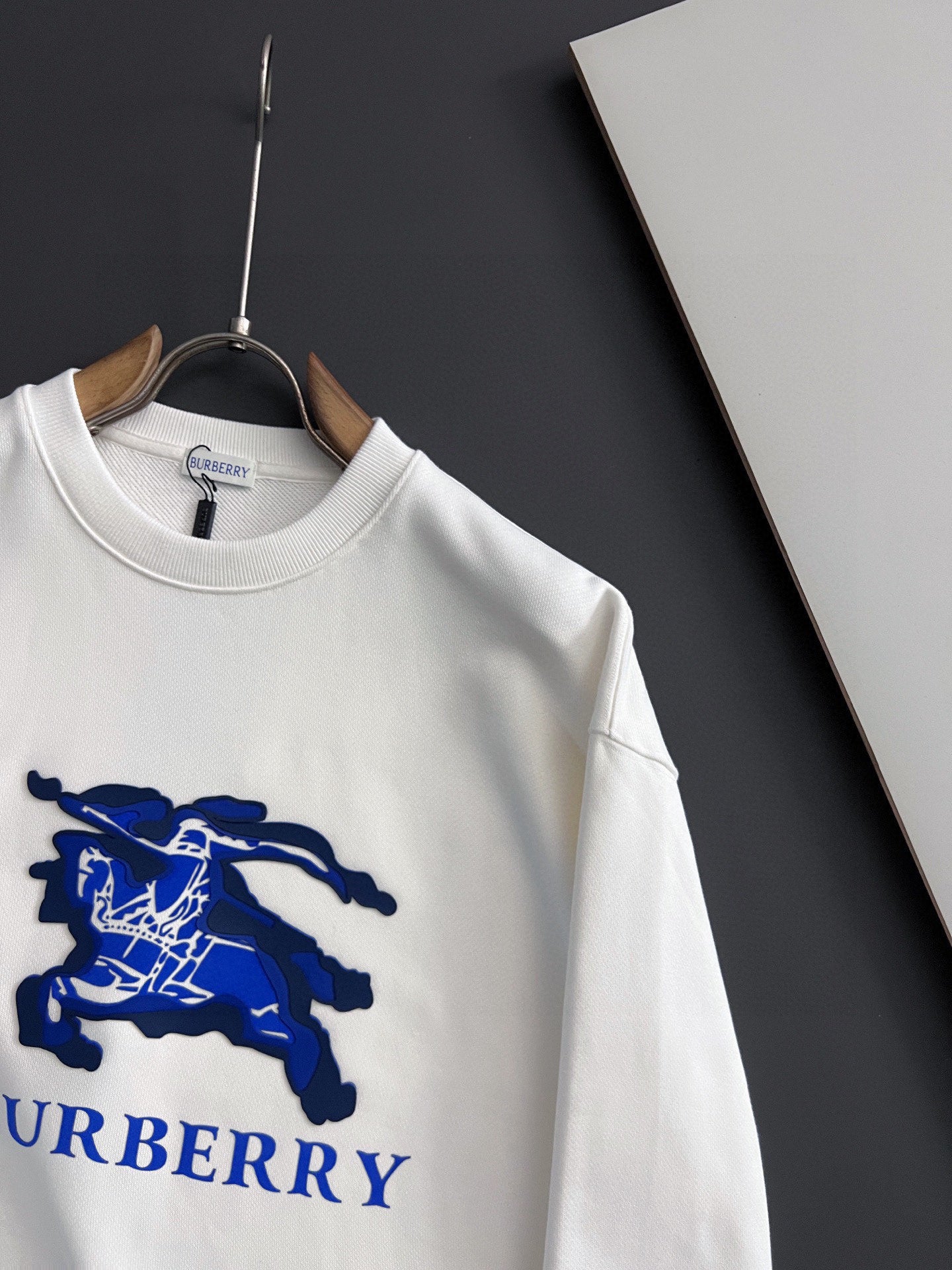 White long-sleeve sweatshirt with large blue horse logo and partial Burberry text