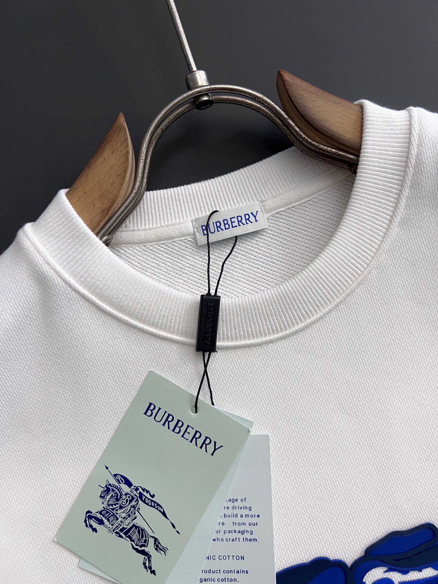 White long-sleeve sweatshirt with ribbed crew neck and hanging Burberry label