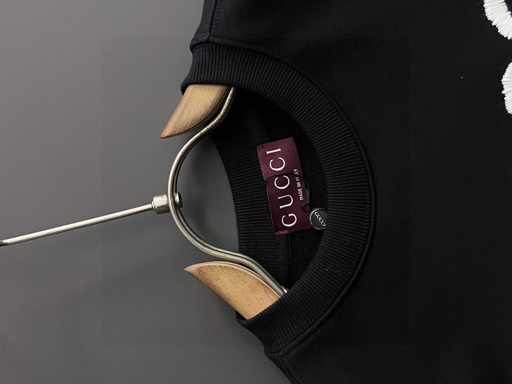 Black Gucci crewneck sweatshirt neckline with hanging metal hook and neck label