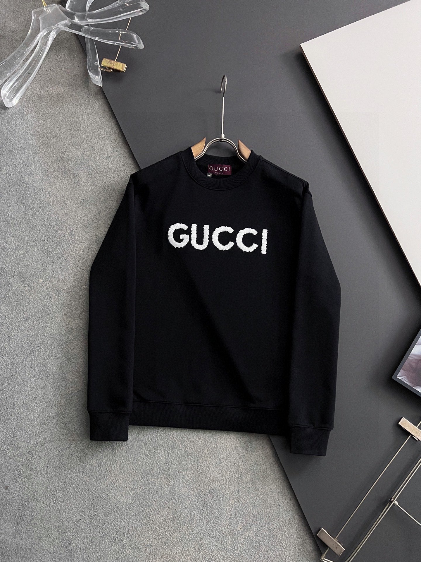 Black Gucci crewneck sweatshirt with white “GUCCI” logo lettering