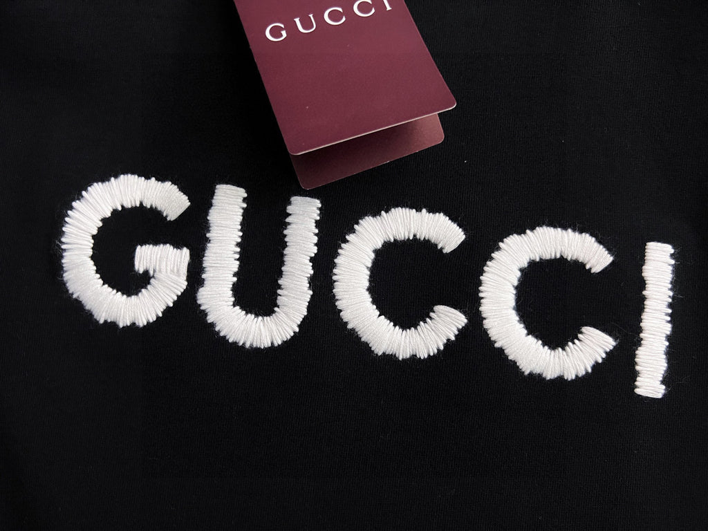 Black Gucci sweatshirt with full white embroidered “GUCCI” logo lettering