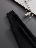 Folded black long-sleeve sweatshirt pieces with ribbed fabric