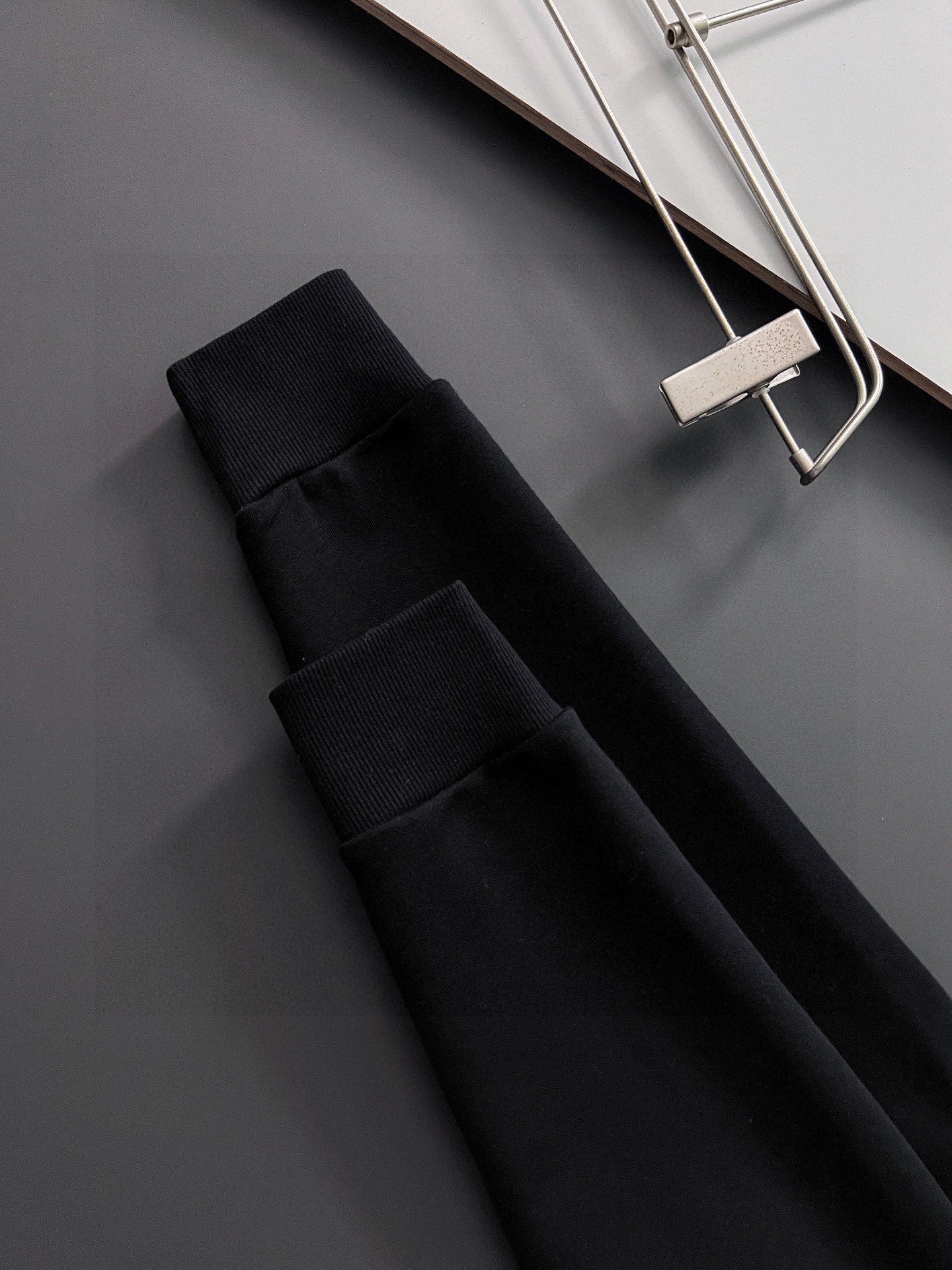 Folded black long-sleeve sweatshirt pieces with ribbed fabric