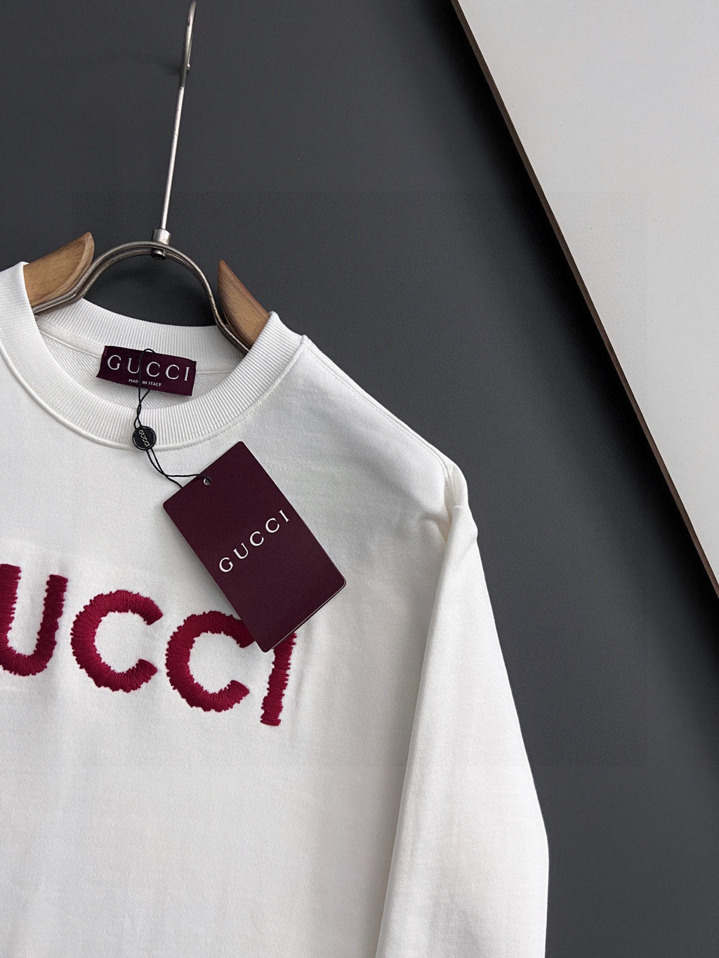 White Gucci long-sleeve sweatshirt with red GUCCI logo detail and hanging tag