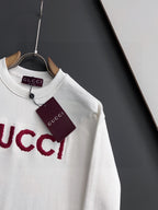 White Gucci long-sleeve sweatshirt with red GUCCI logo detail and hanging tag