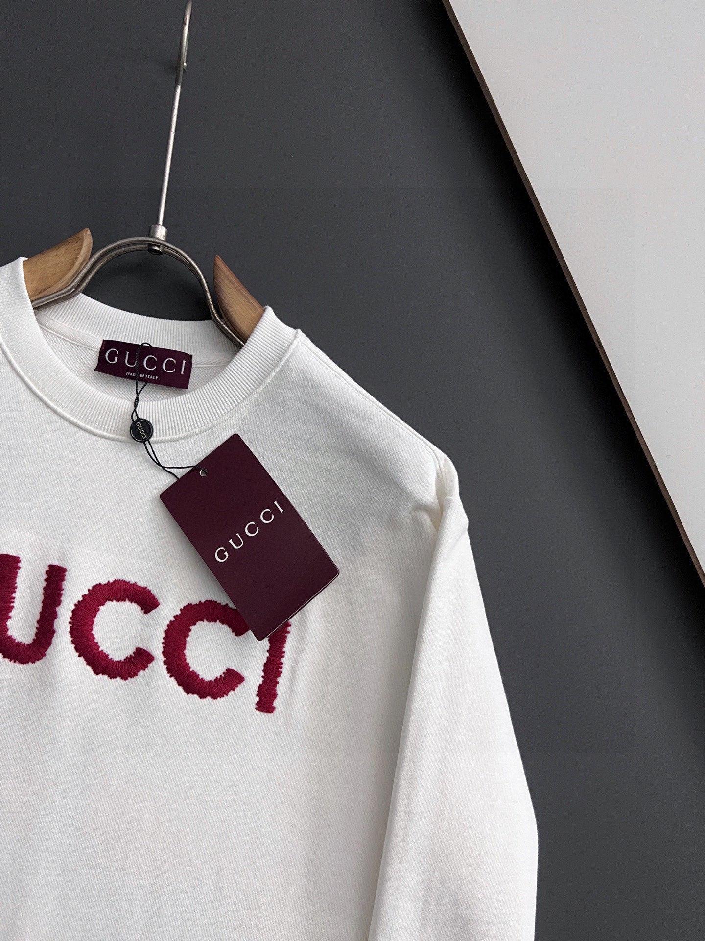 White Gucci long-sleeve sweatshirt with red GUCCI logo detail and hanging tag