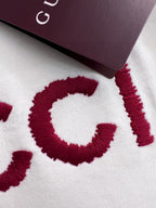 White sweatshirt fabric close-up with red GUCCI lettering