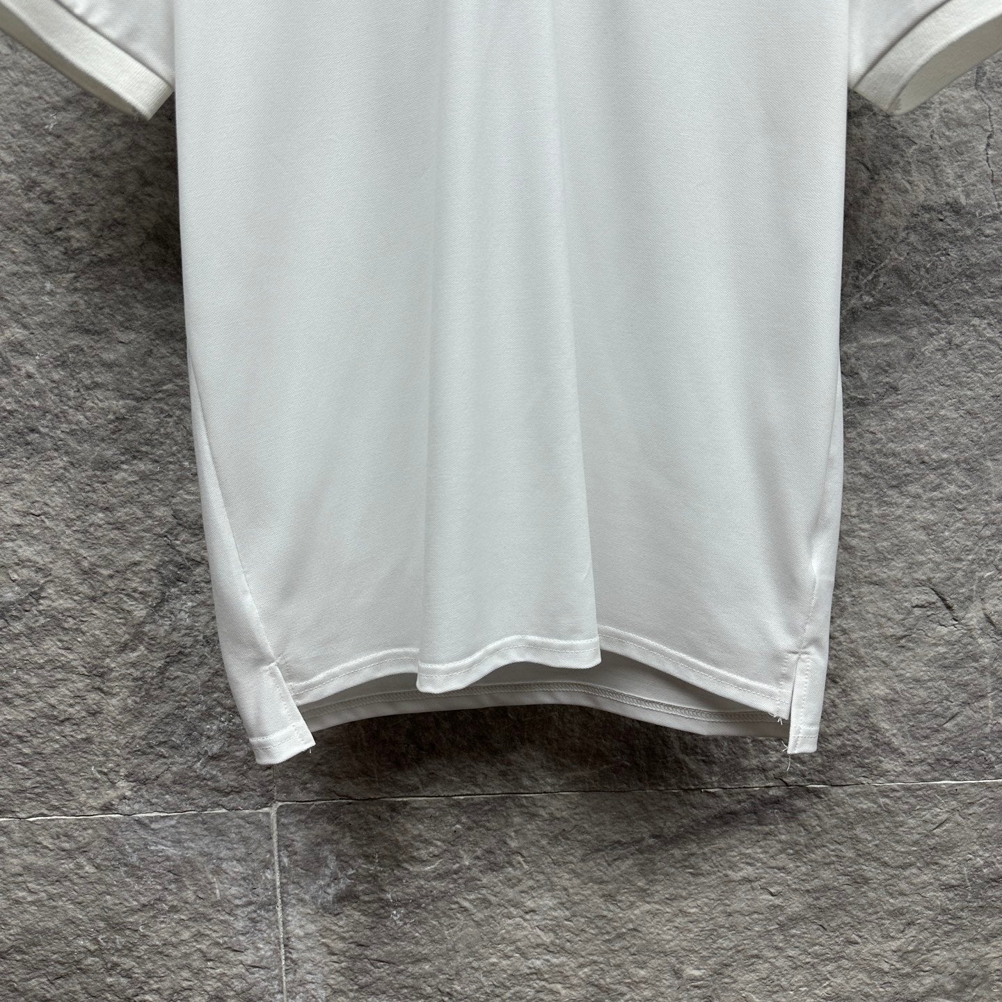 Gucci short-sleeve polo shirt hem, white with straight bottom edge.