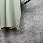 Mint green polo shirt partial view with curved hem and short sleeve