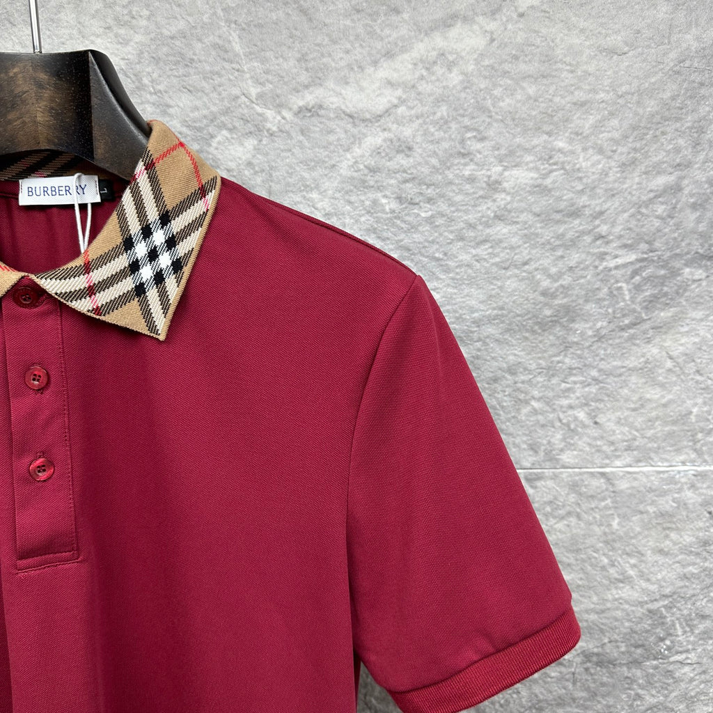 Maroon polo shirt shoulder and collar with Burberry check trim.