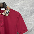 Maroon polo shirt shoulder and collar with Burberry check trim.