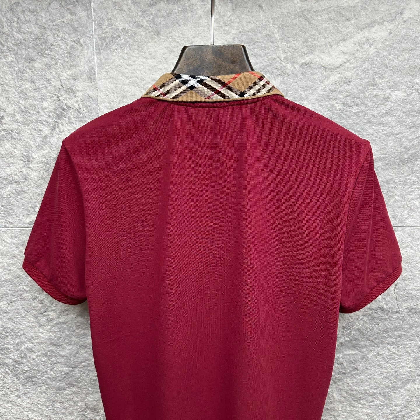Maroon short-sleeve polo shirt, back view with check collar trim.