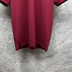 Maroon short-sleeve polo shirt hem and back vent detail.