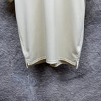 Cream polo shirt with curved hem and side vent, hanging