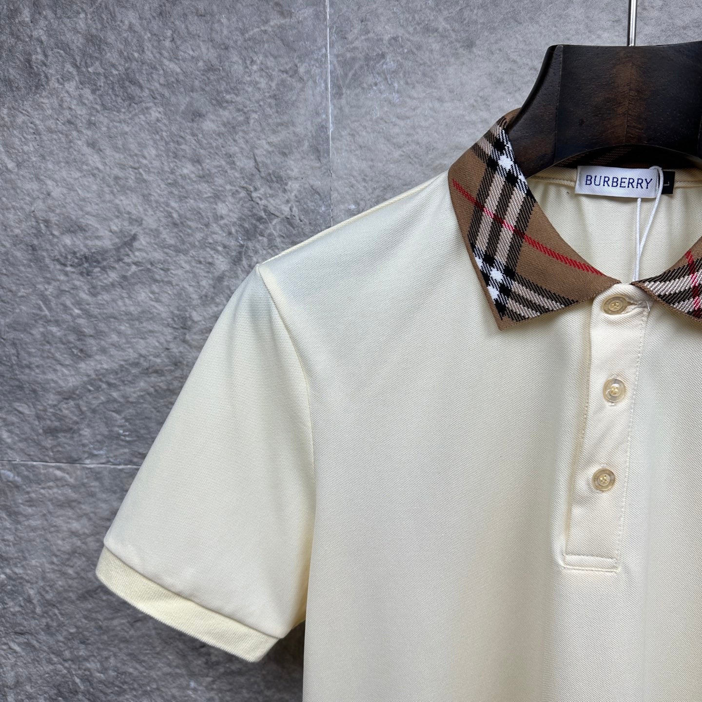 Cream polo shirt with check collar detail and button placket, side view