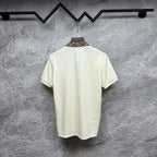 Cream polo shirt back view with check-trim collar on hanger