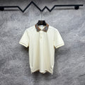 Cream polo shirt with check collar and button placket on a hanger
