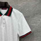 Gucci white polo shirt with embossed GG pattern and green-red striped sleeve edge.