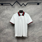 Gucci white polo shirt with green and red striped collar, short sleeves.