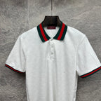 Gucci white polo shirt with embossed GG pattern and green-red striped collar.