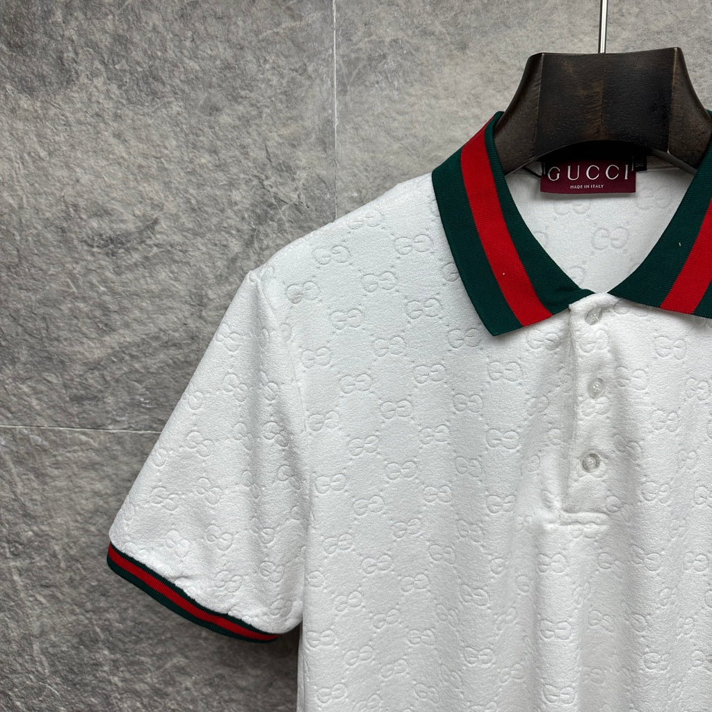 Gucci white polo shirt with textured GG pattern, striped collar, button placket.