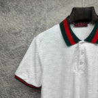 Gucci white polo shirt with textured GG pattern, striped collar, button placket.