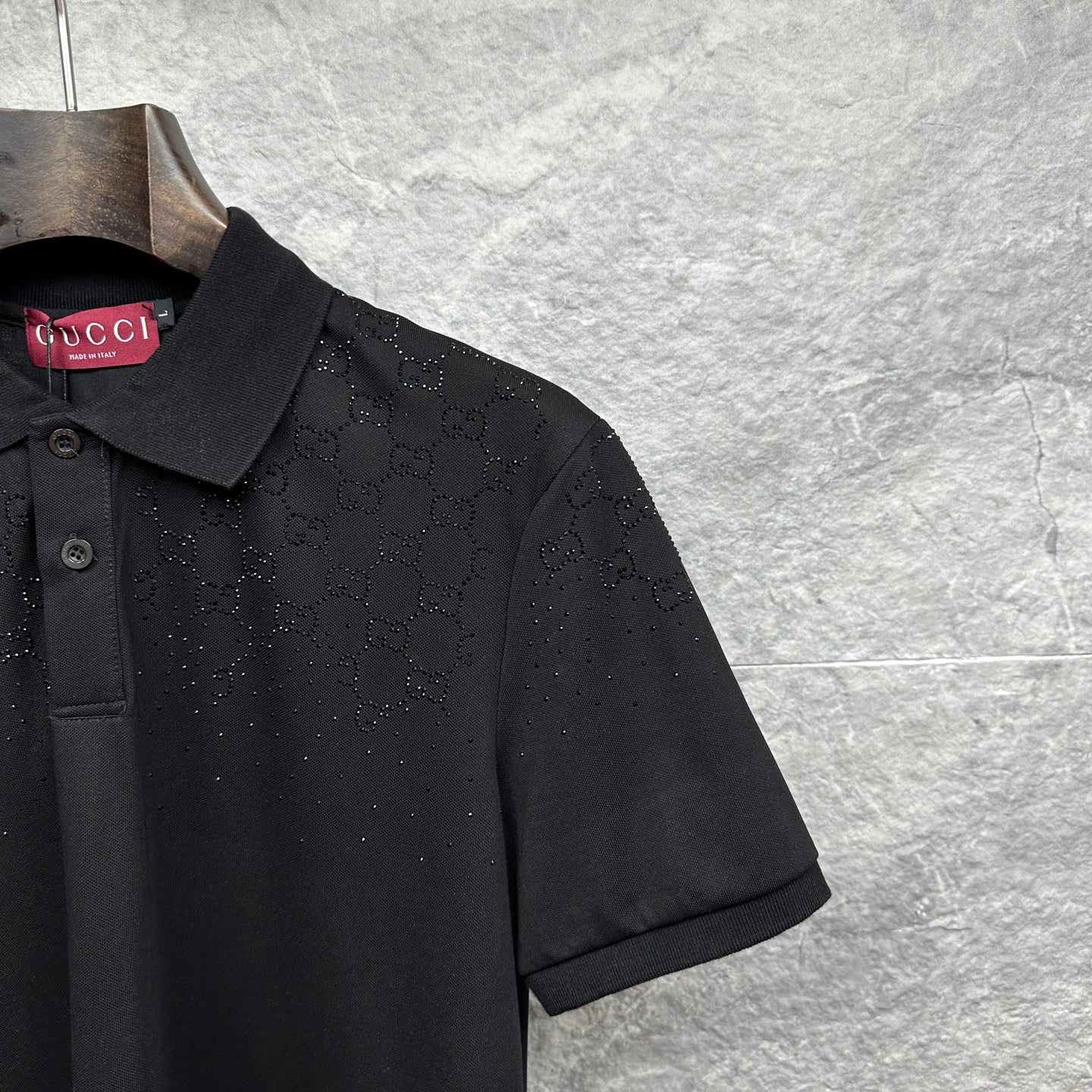 Black Gucci polo shirt sleeve with GG pattern and textured dots