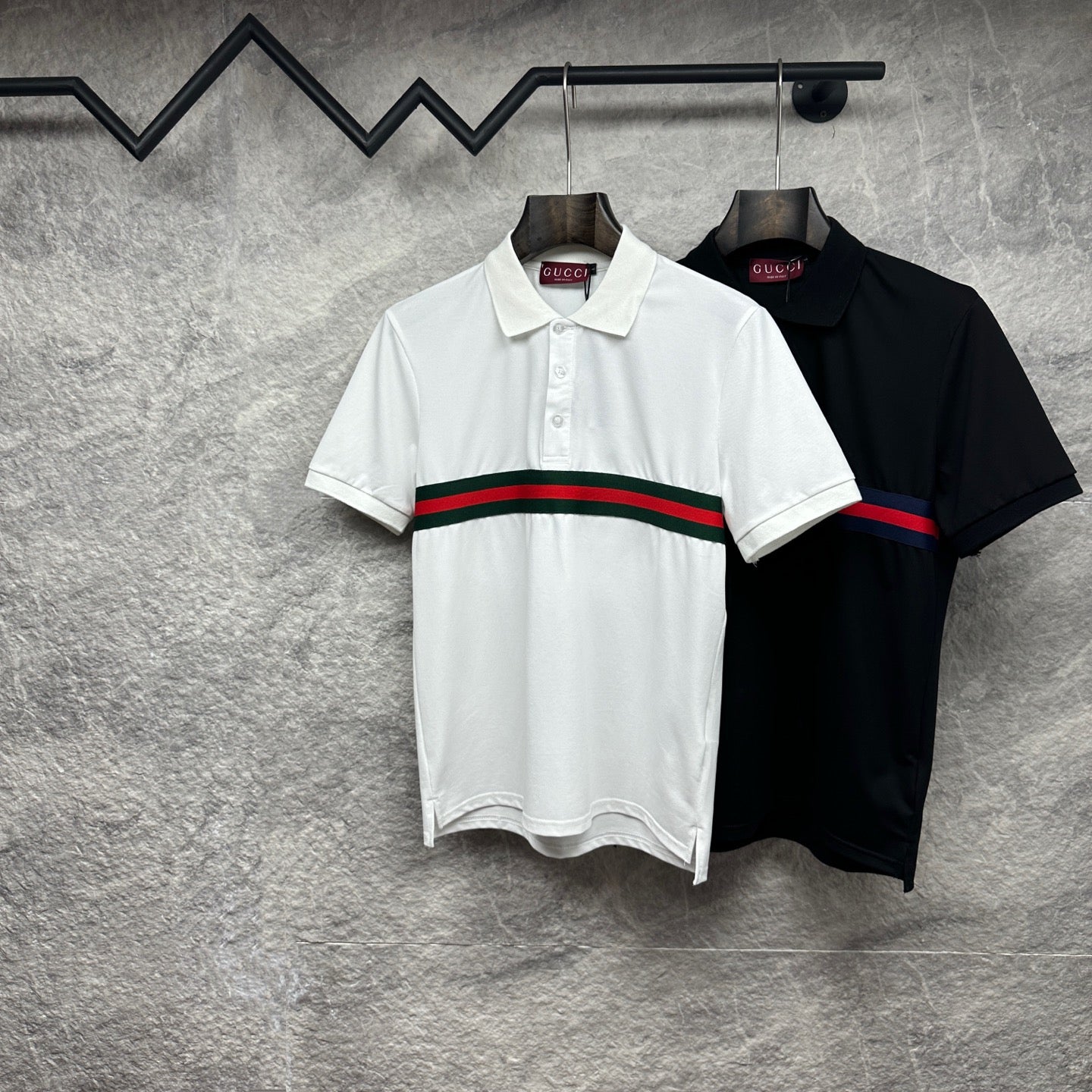 Gucci polo shirts in white and black, both with red and green striped chest band