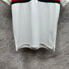 Gucci polo shirt in white with hem side slits and red and green striped band at waist