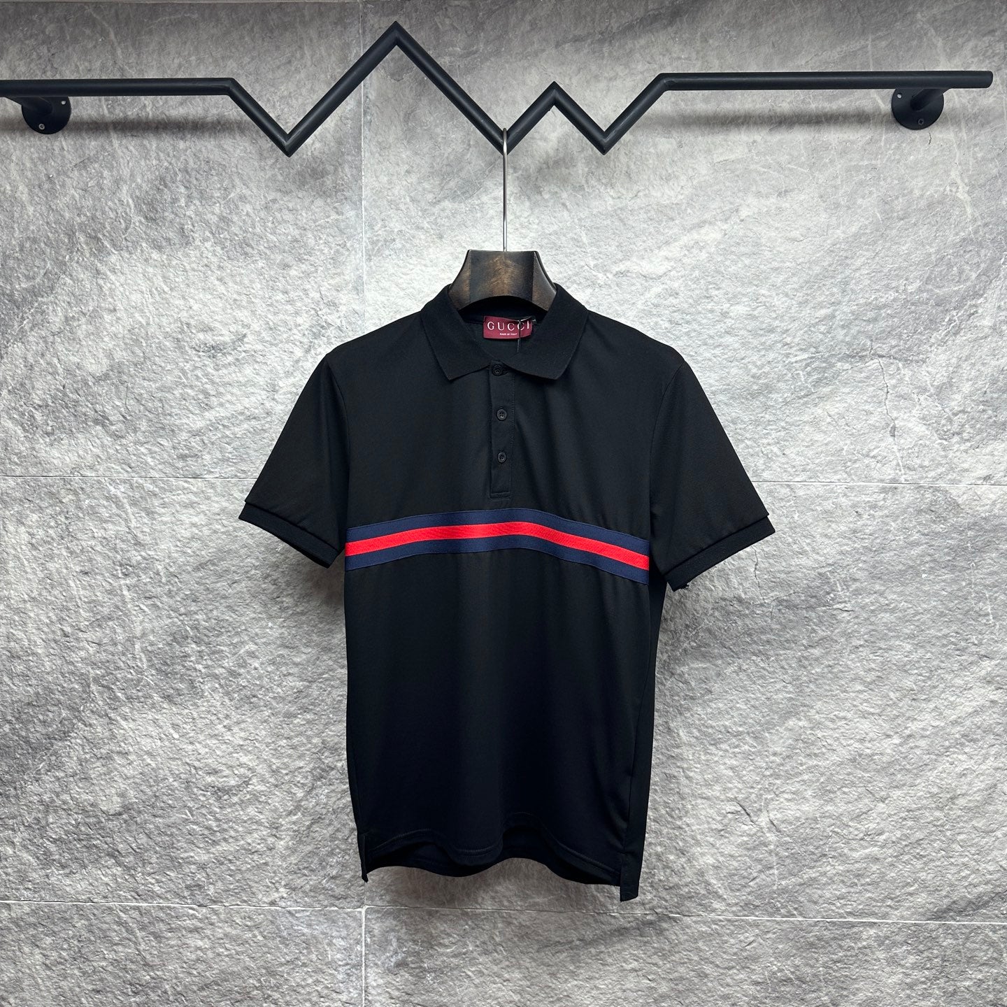 Black Gucci polo shirt with striped band at chest and buttoned collar.