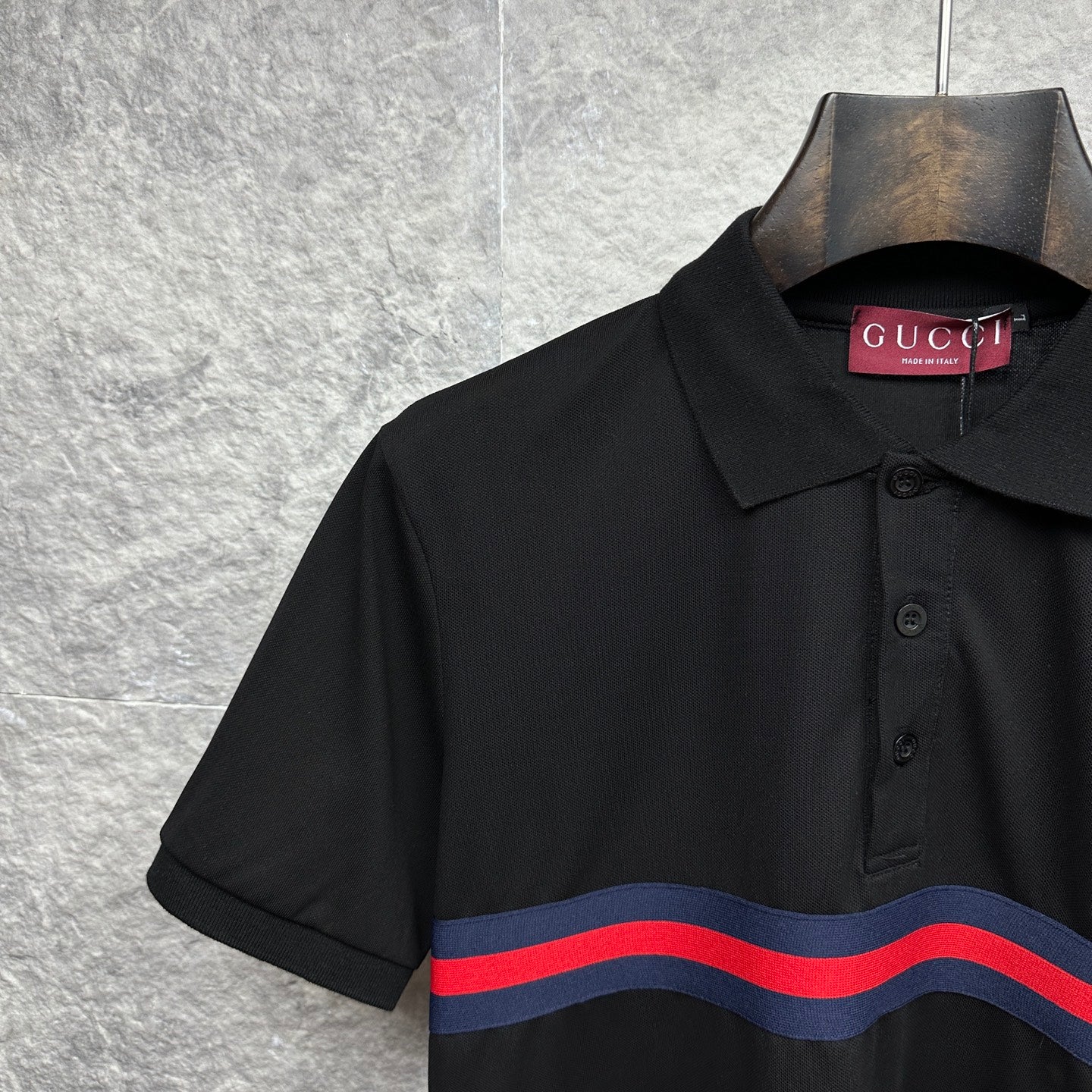 Black Gucci polo shirt close-up of collar and striped chest band.