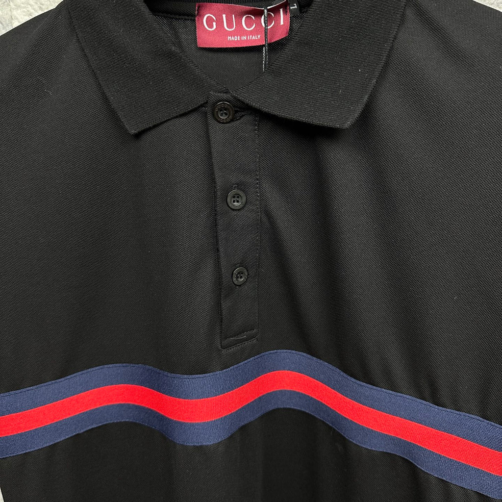 Black Gucci polo collar close-up with buttons and blue-red striped band.