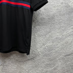 Black Gucci polo shirt side hem with blue-red striped band at chest.