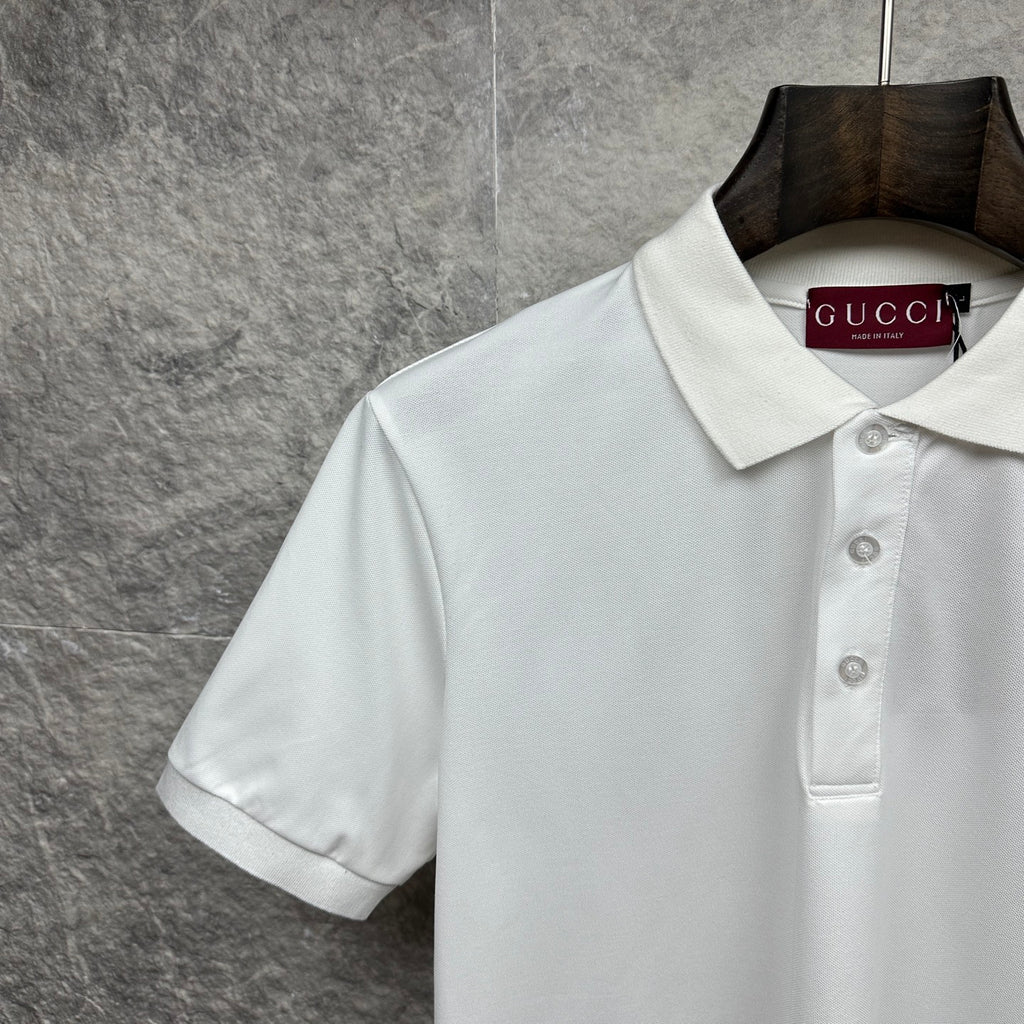 White Gucci polo shirt close-up of collar, buttons, and chest logo
