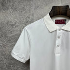 White Gucci polo shirt close-up of collar, buttons, and chest logo