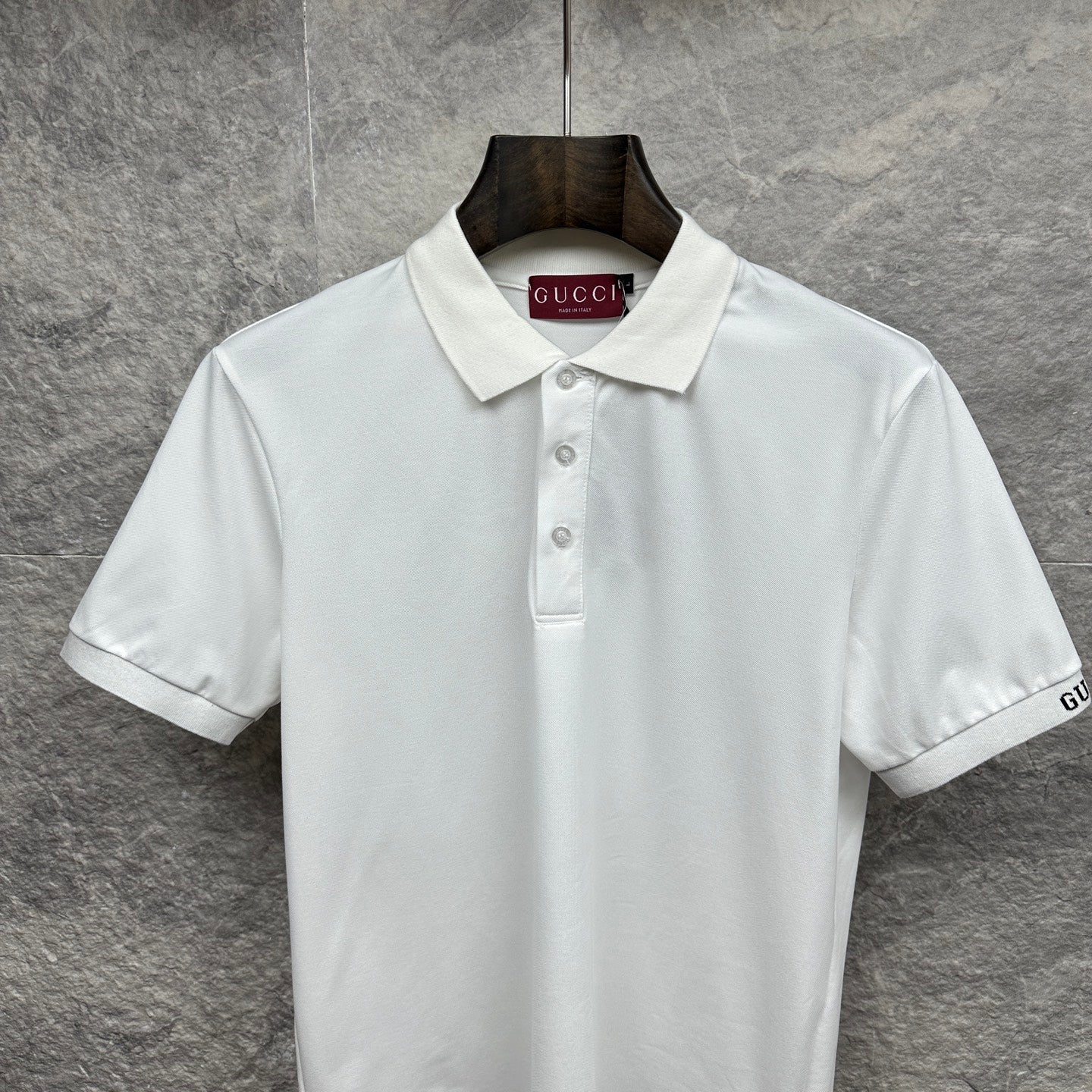 White Gucci polo shirt with pointed collar, button placket, and GUCCI neck label