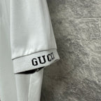 White Gucci polo shirt sleeve cuff with GUCCI embroidered band