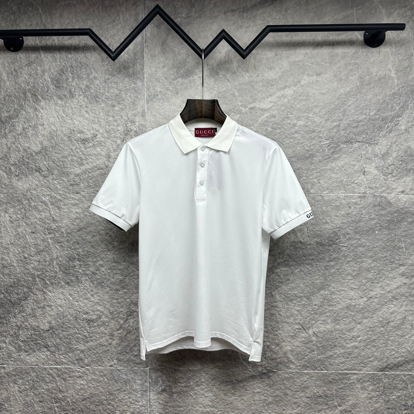 White Gucci polo shirt with button placket and embroidered logo on sleeve