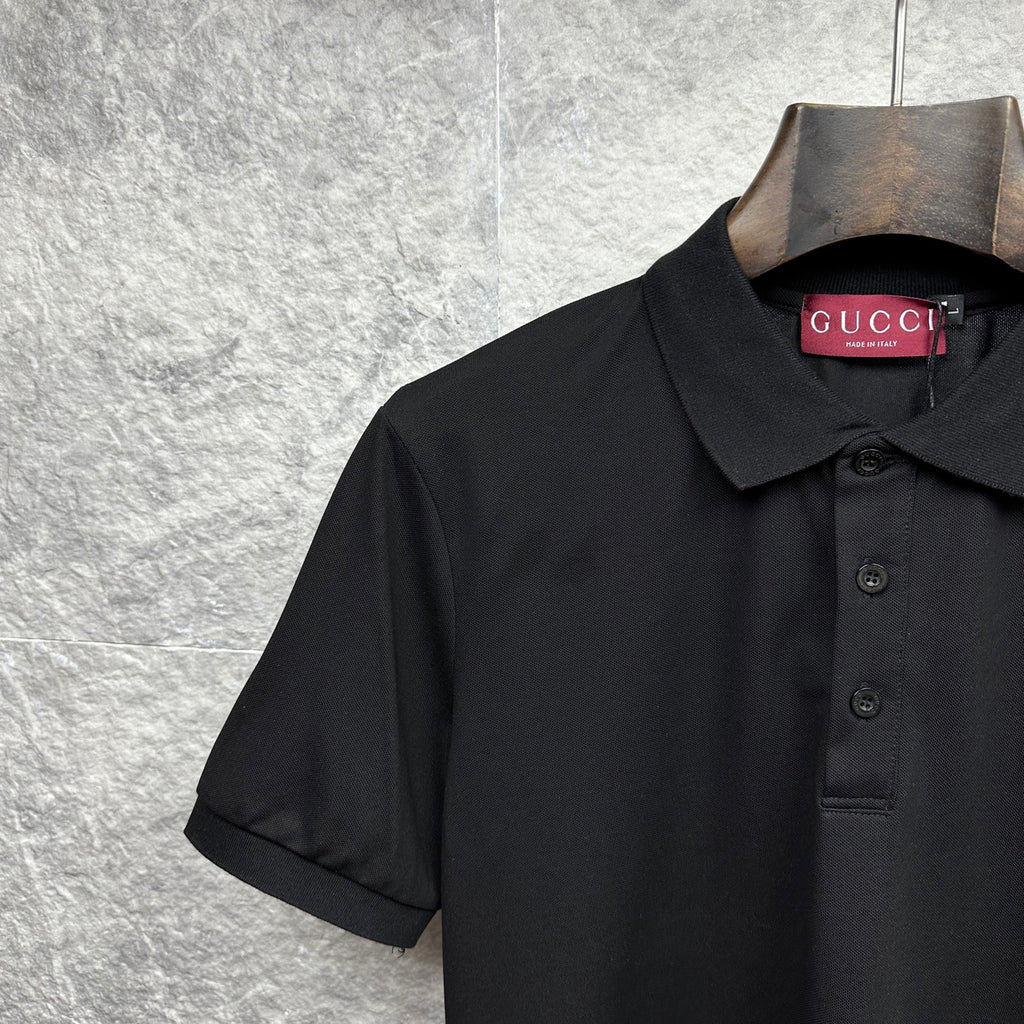 Black Gucci polo shirt with dark button placket and fold-over collar