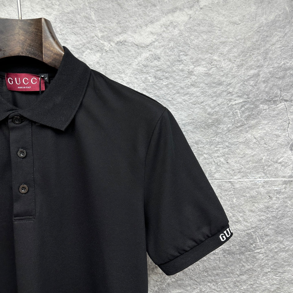 Black Gucci polo shirt sleeve with stitched GUCCI logo cuff