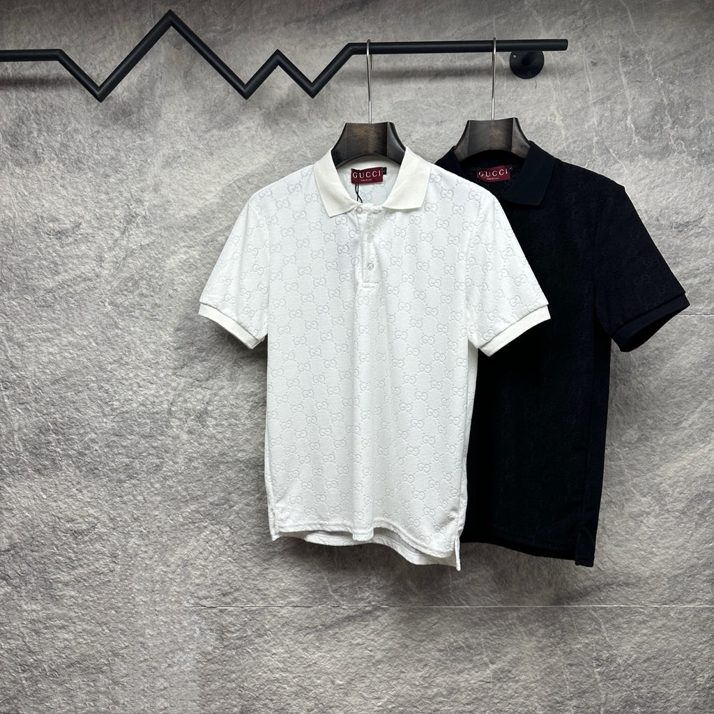 Two Gucci polo shirts hanging: white and black, short sleeves, GG monogram pattern.