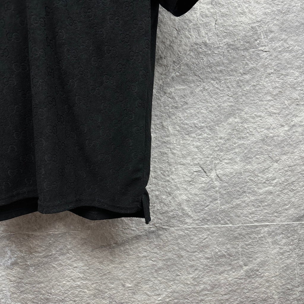 Black Gucci polo shirt, side hem and sleeve edge detail, GG monogram pattern.