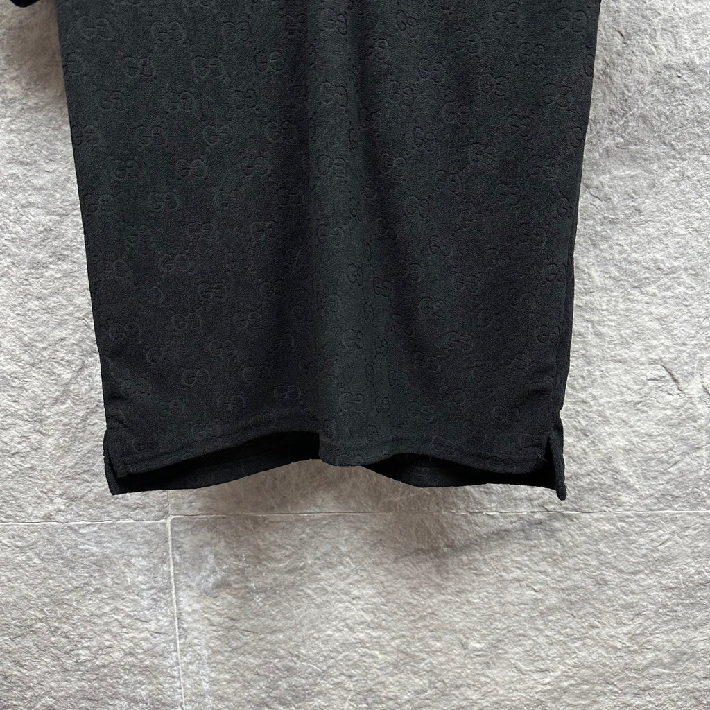 Black Gucci polo shirt, front bottom hem and side seam, GG monogram pattern.