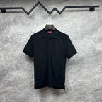 Black Gucci polo shirt, short sleeves, button placket, GG monogram pattern.