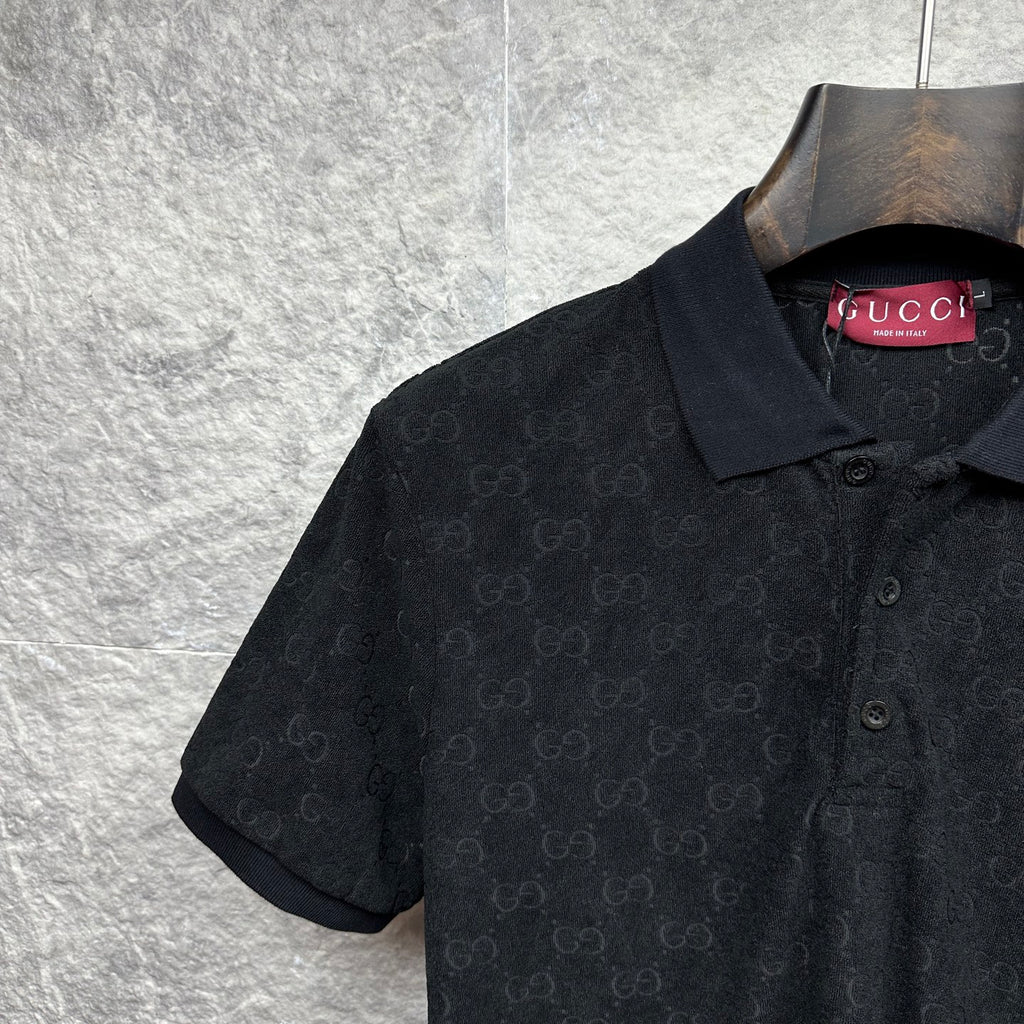 Black Gucci polo shirt, close-up of collar and GG monogram texture.