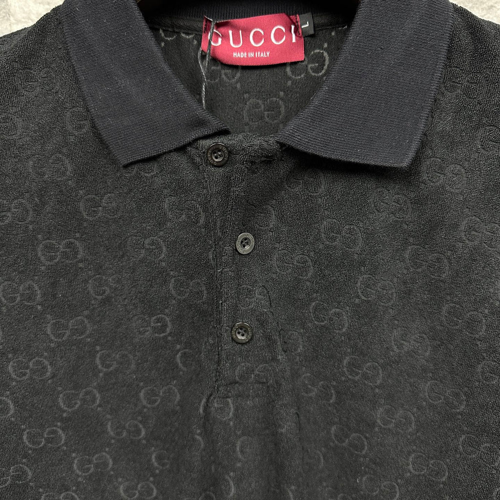 Black Gucci polo shirt neckline close-up, three-button placket, GG monogram.