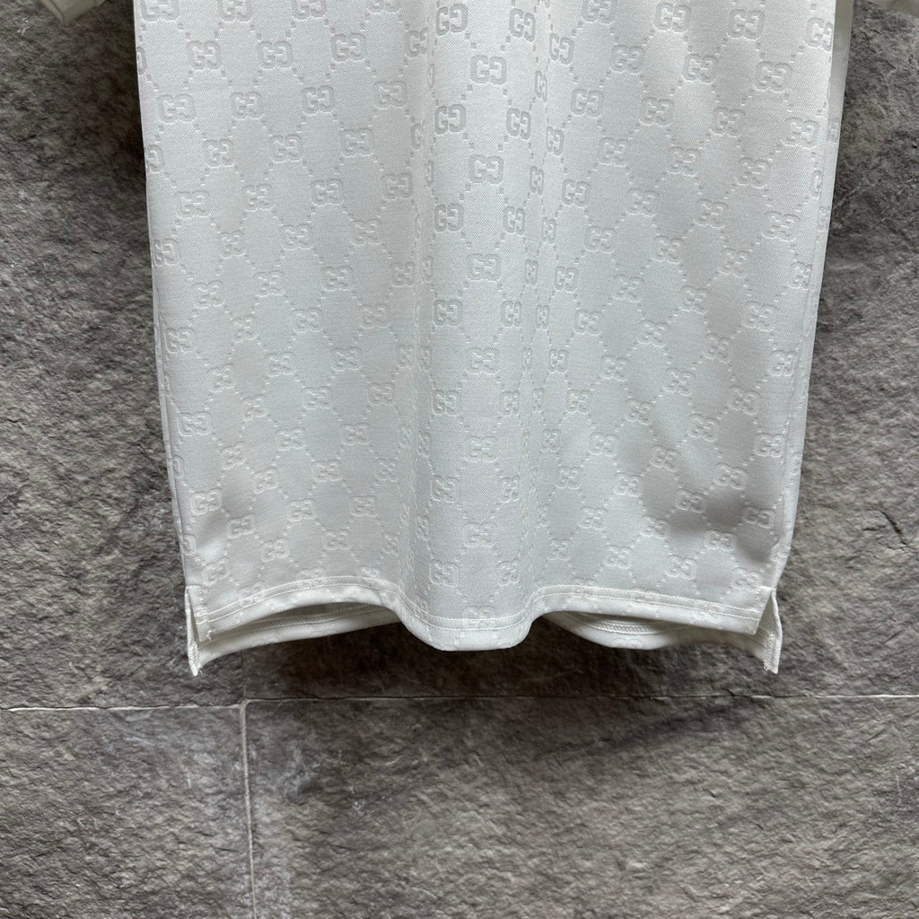 White Gucci polo shirt hem with subtle GG pattern and button-front placket edge