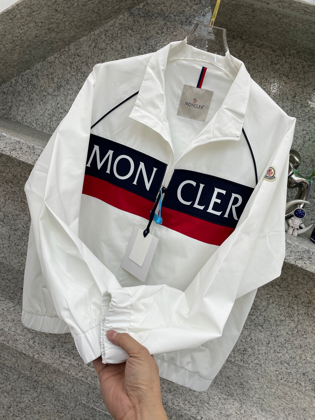 Moncler jacket, white with navy/red logo stripe and zip front on hanger