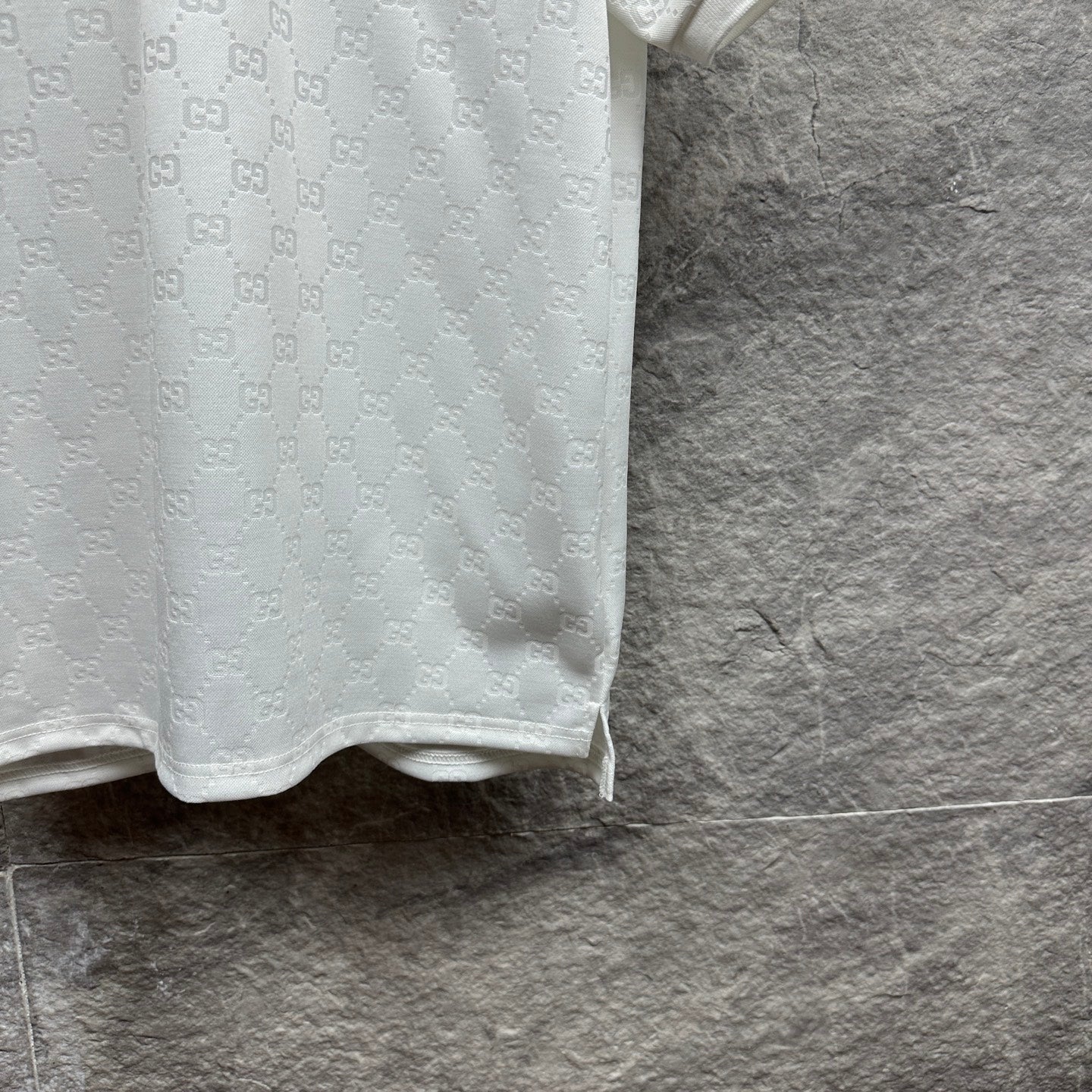 White Gucci polo shirt side view with GG pattern, sleeve cuff and hem