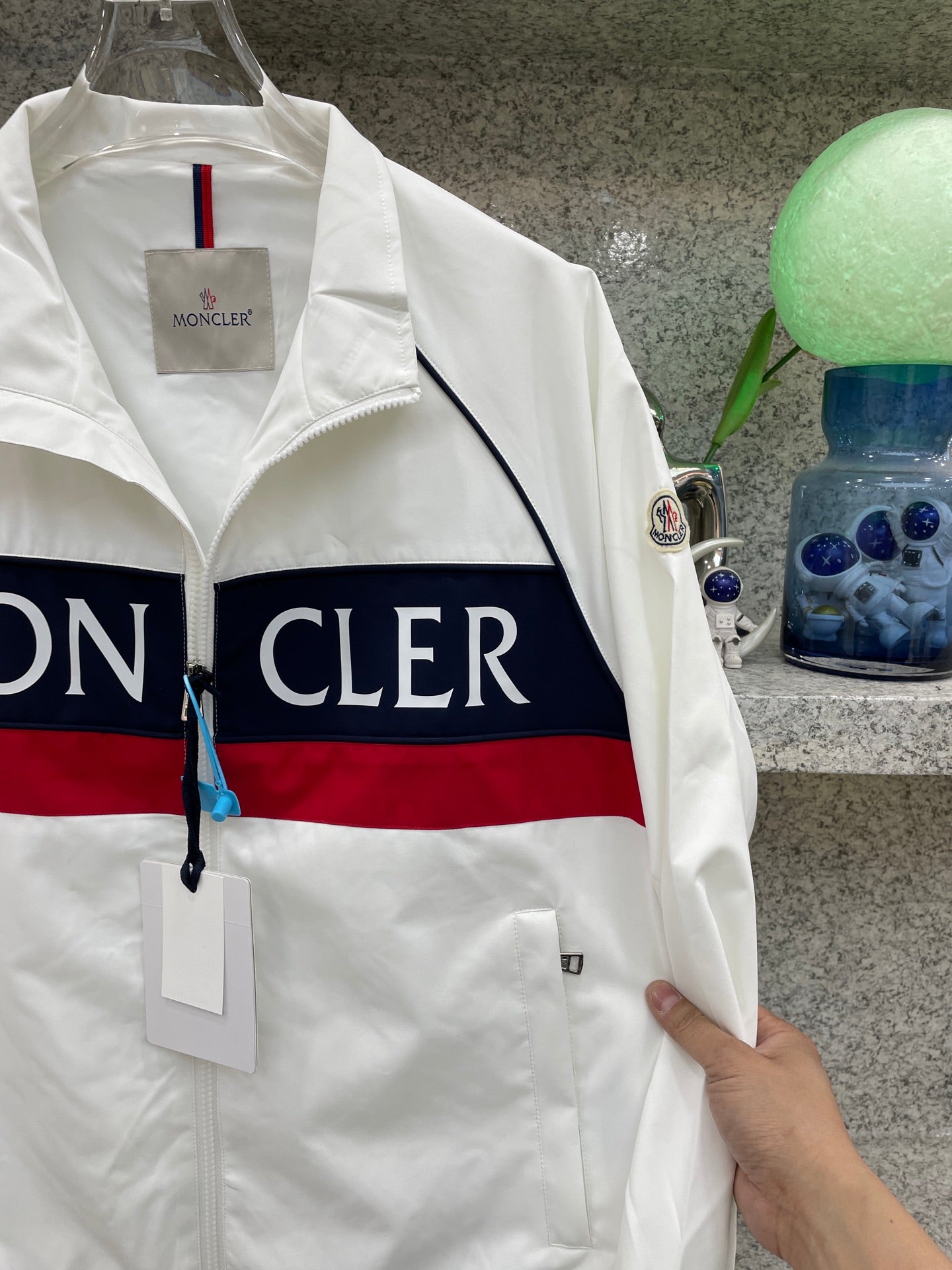 Moncler jacket side, white with navy/red logo stripe and sleeve patch